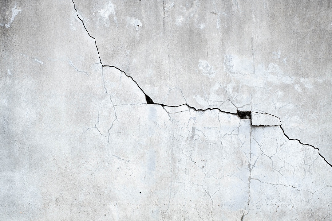 O velho muro de cimento está quebrado e preto e branco, fundo de cimento