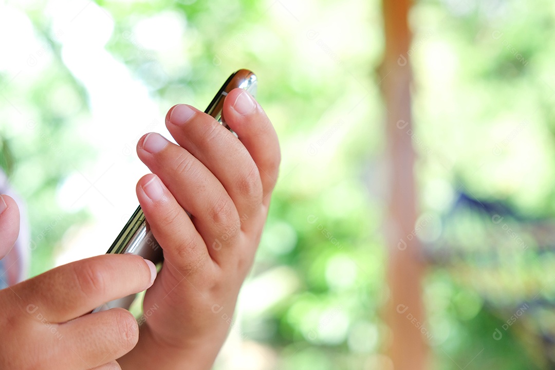 Menina asiática bonitinha jogando telefone inteligente em casa