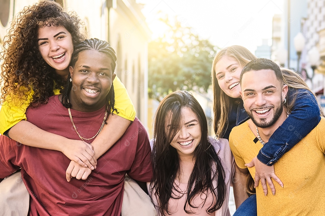 Jovens multirraciais andam alegremente nas ruas da cidade em passeios nas costas - Garotos e garotas se divertindo juntos - Conceito de estilo de vida