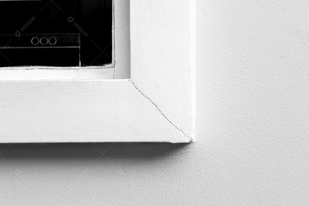 Cornija da janela branca rachada no canto causada pela inexperiência dos construtores na instalação, janelas quebradas, paredes da casa danificadas.