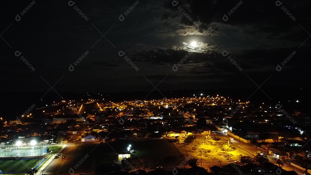 Imagem noturnas aéreas de uma cidade pequena em lua cheia