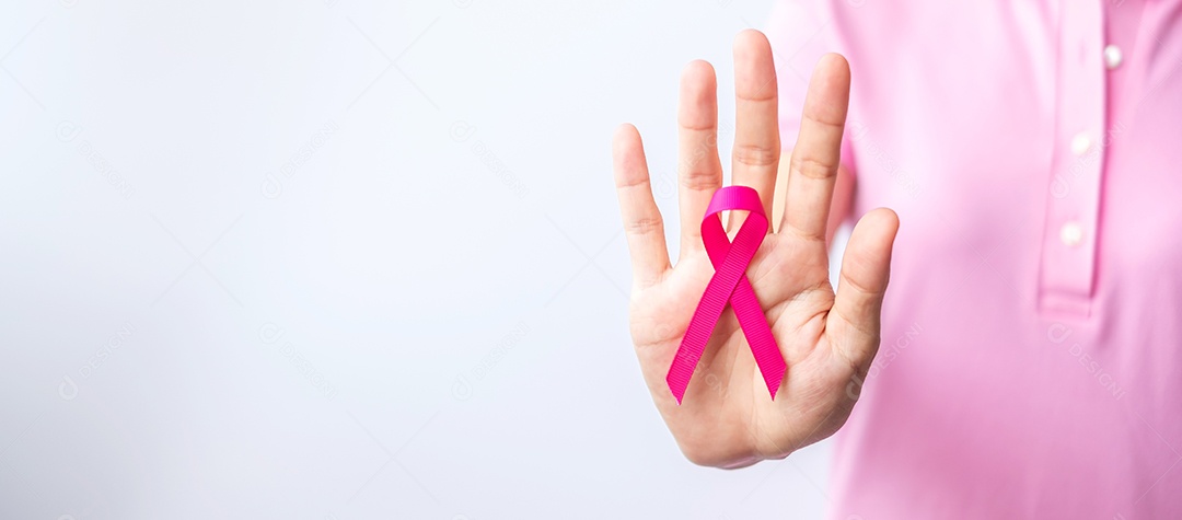 Mês de conscientização do câncer de mama de outubro rosa, a mão da mulher segura a fita rosa conceito do Dia Mundial da Mãe e do Câncer