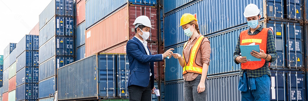 Capataz de armazém logístico dando gel de álcool para grupo de trabalhadores