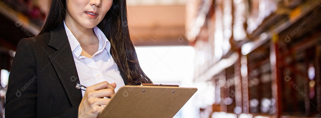 Pessoas de negócios escrevendo na área de transferência no armazém de distribuição