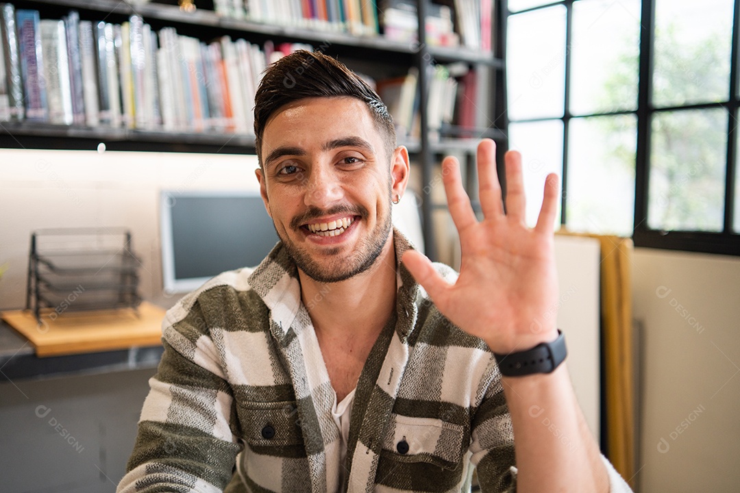 Retrato de um jovem bonito sorrindo acenando com a mão para cumprimentar