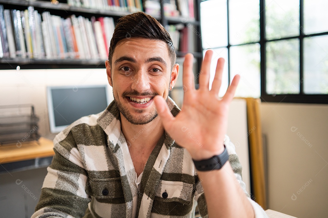 Retrato de um jovem bonito sorrindo acenando com a mão para cumprimentar