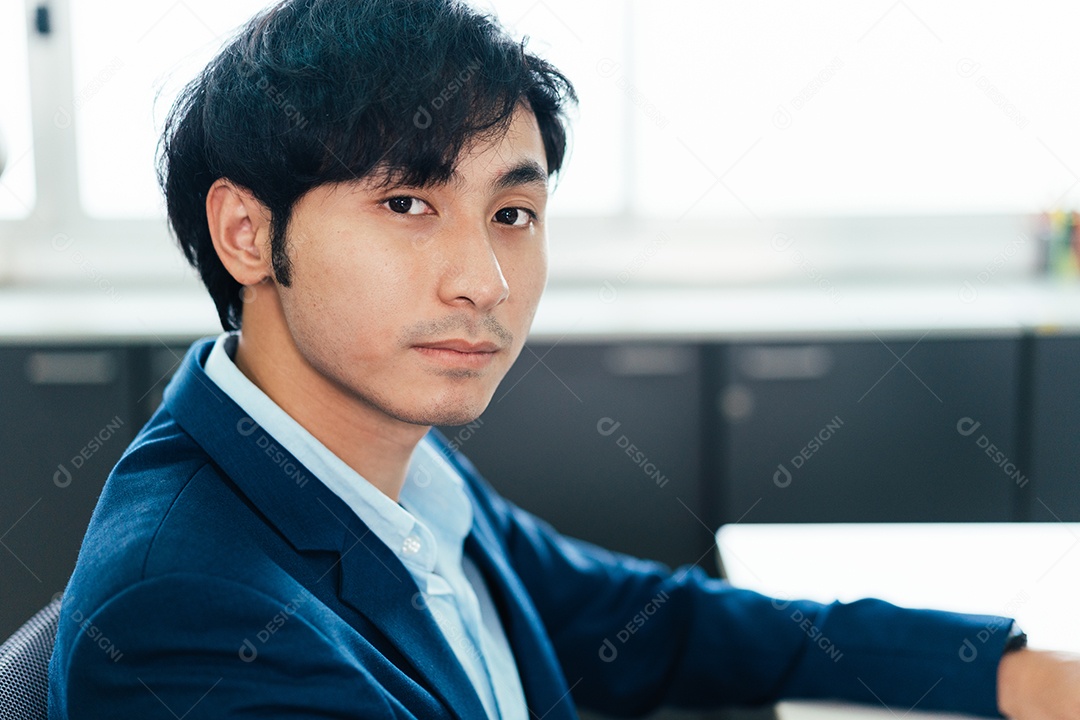 Retrato de homem de negócios asiáticos sentado à mesa no escritório