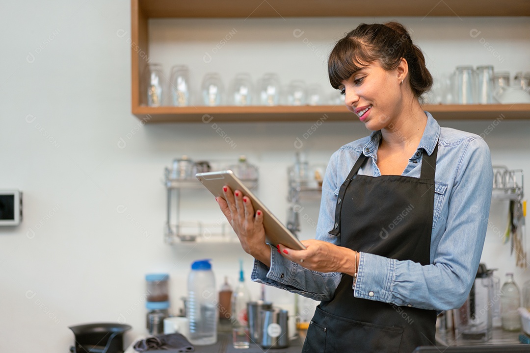 Proprietária de cafeteria feminina sorridente usando o recebimento de tablet digital