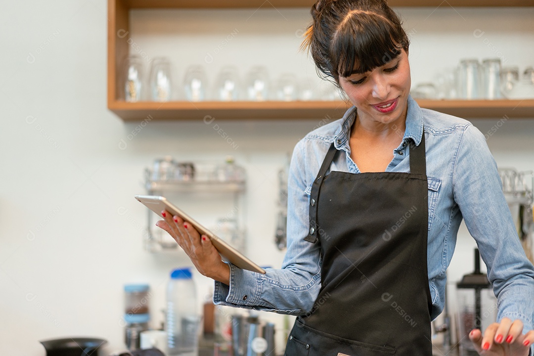 Proprietária de cafeteria feminina sorridente usando o recebimento de tablet digital