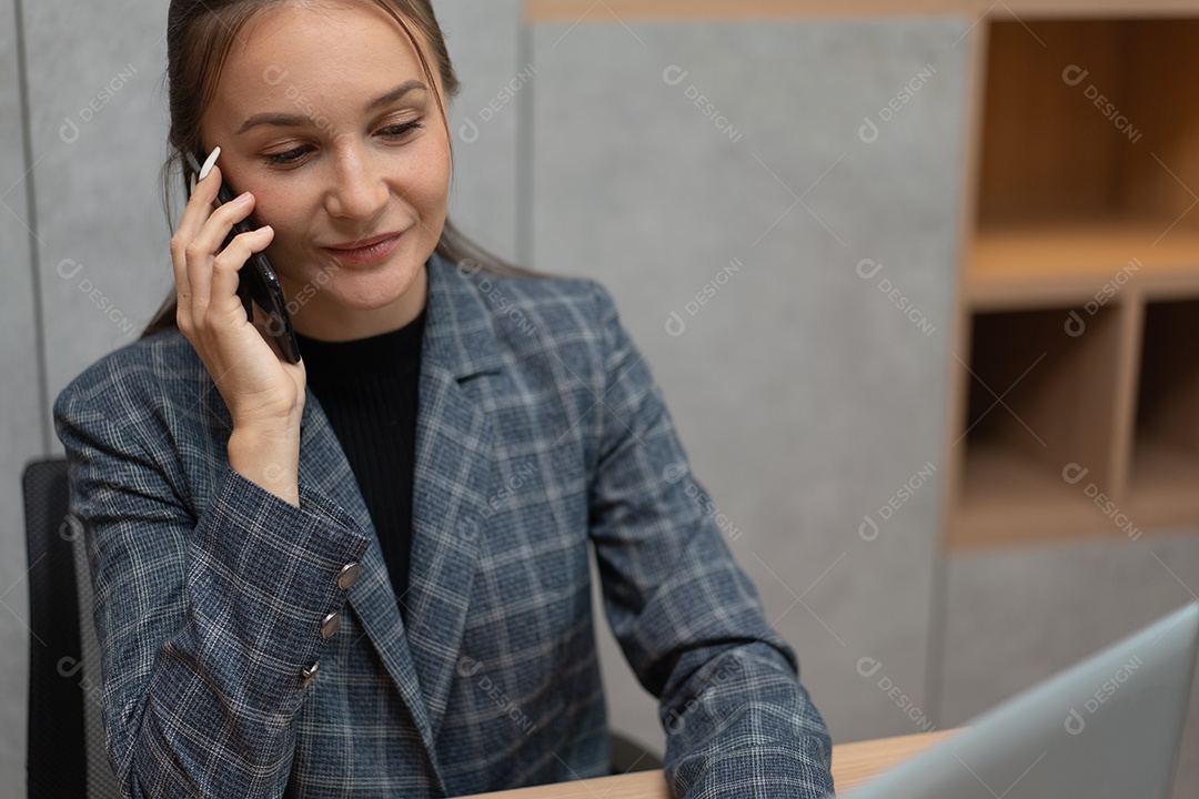 Secretária ou funcionária falando ao telefone no escritório