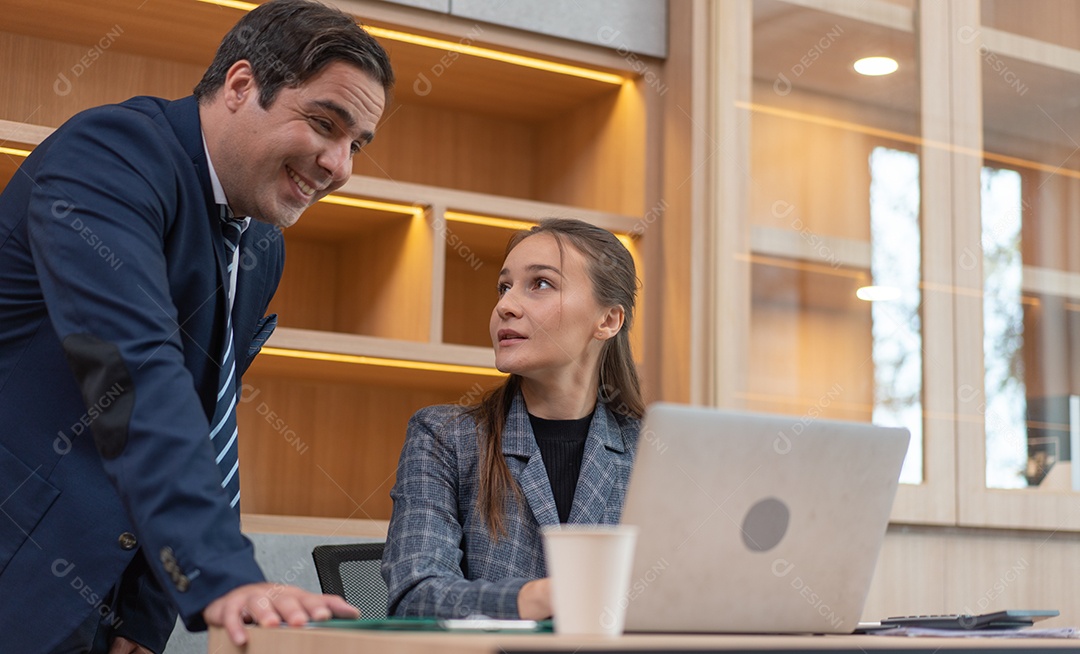 Gerente masculino assistindo projeto no laptop com assistente feminina