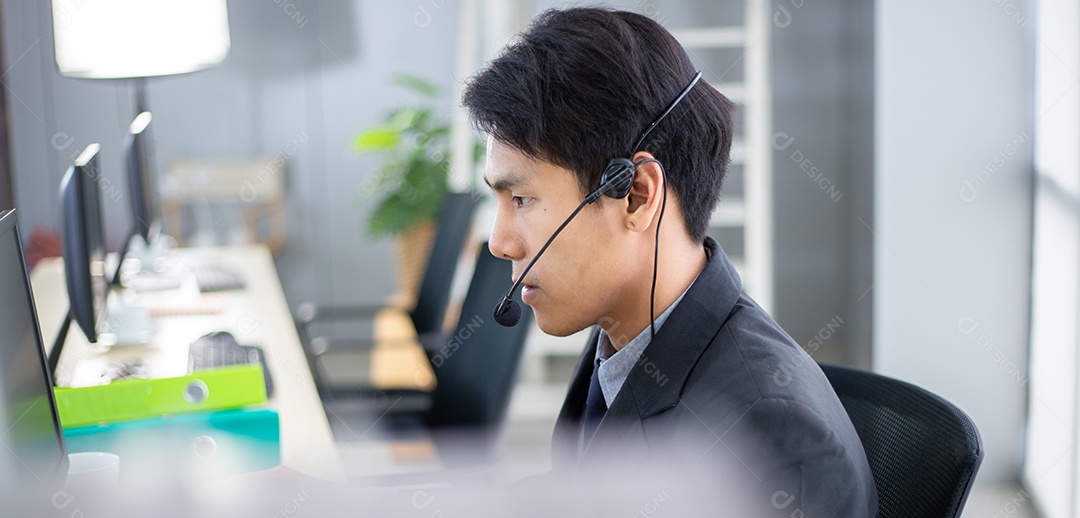 Centro de atendimento masculino asiático com fone de ouvido conversando com o cliente