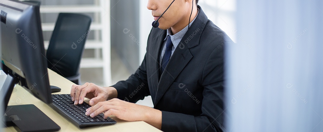 Centro de atendimento masculino asiático com fone de ouvido conversando com o cliente