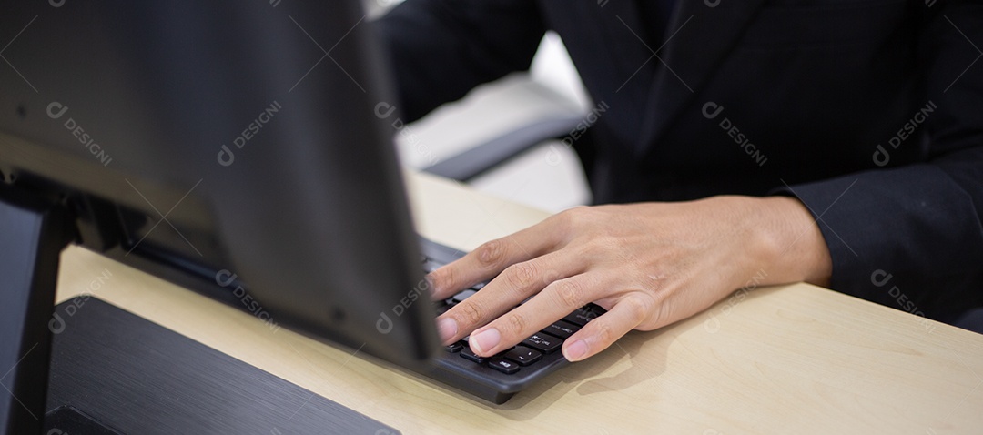 Mão de funcionário do sexo masculino digitando no teclado do computador na mesa