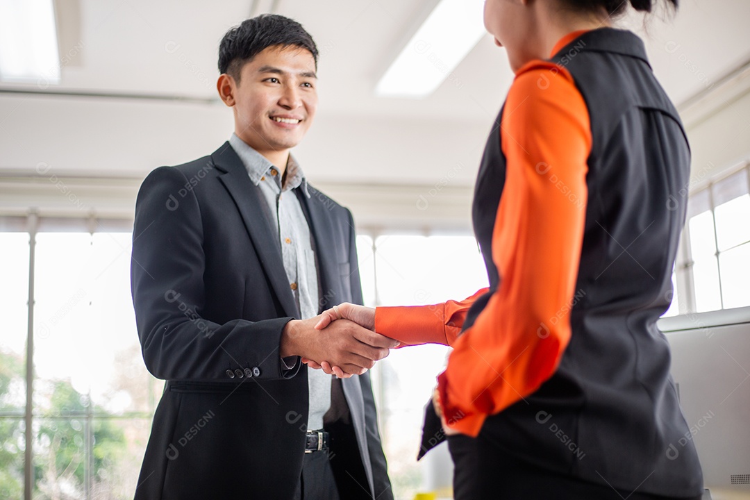 Homem asiático sorridente apertando a mão com a parceria do colega