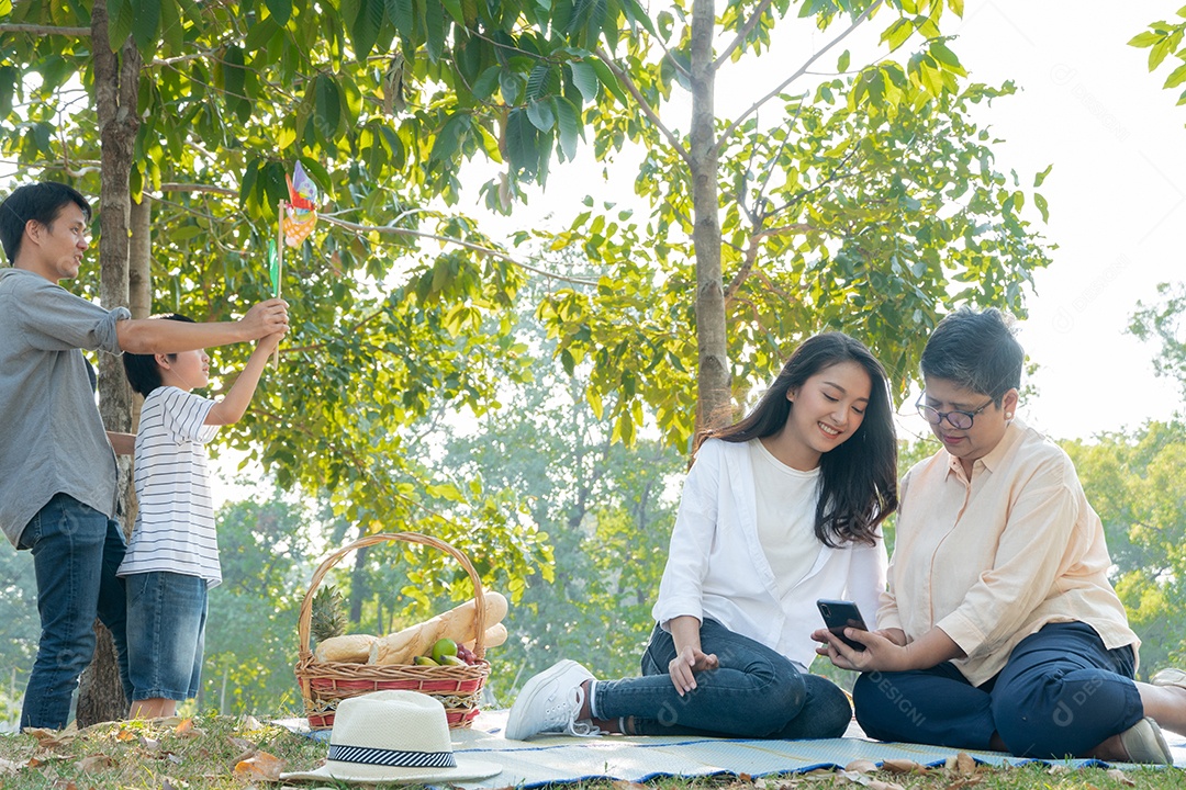 Filha asiática ensinando mãe usando e jogando no celular