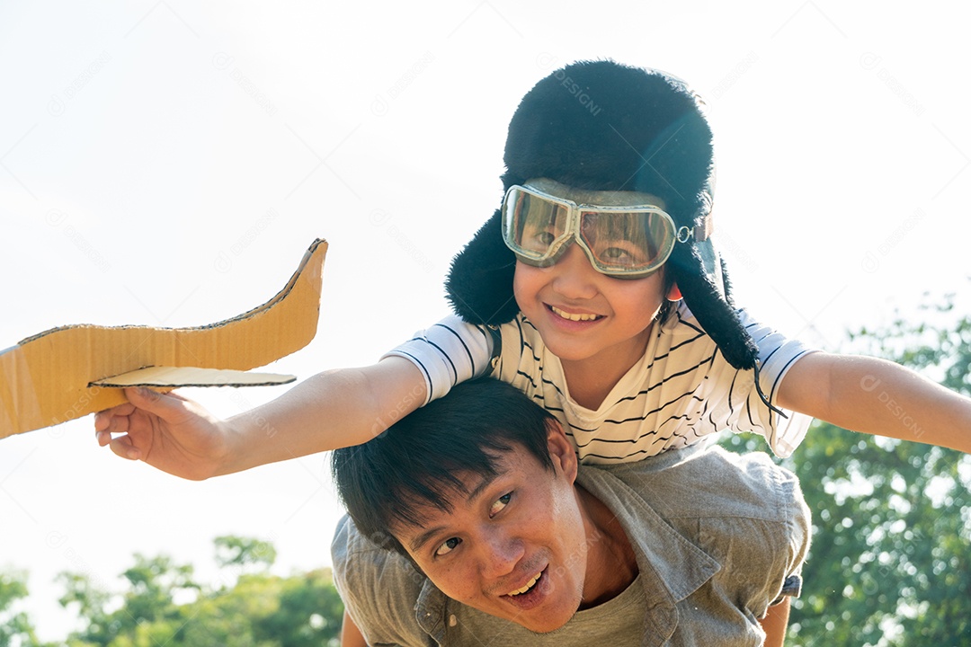 Garoto asiático usando capacete de piloto jogando brinquedo de avião