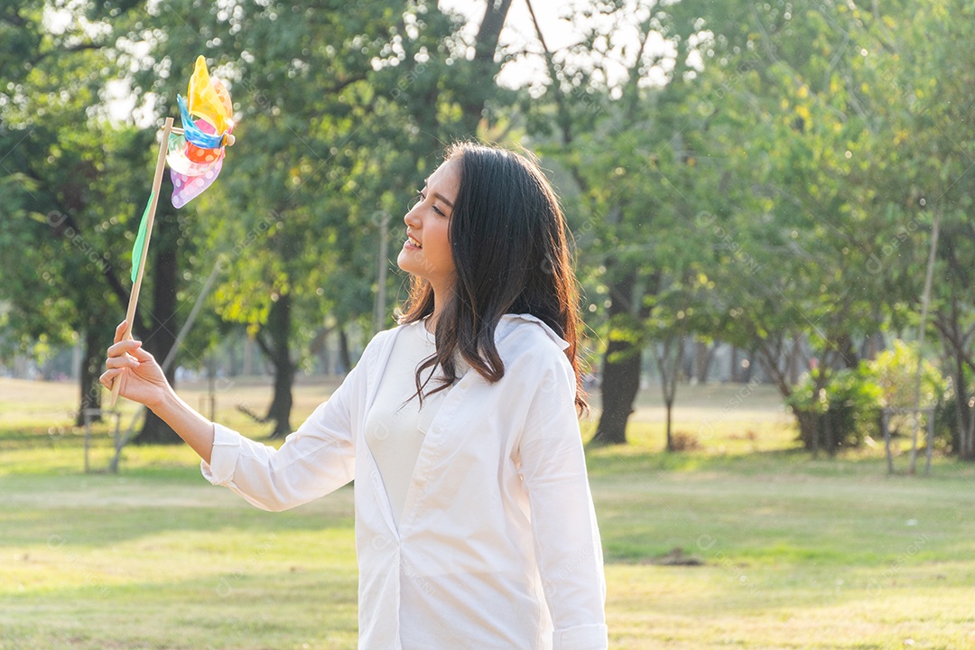 Mulher saudável asiática feliz jogando uma turbina no parque
