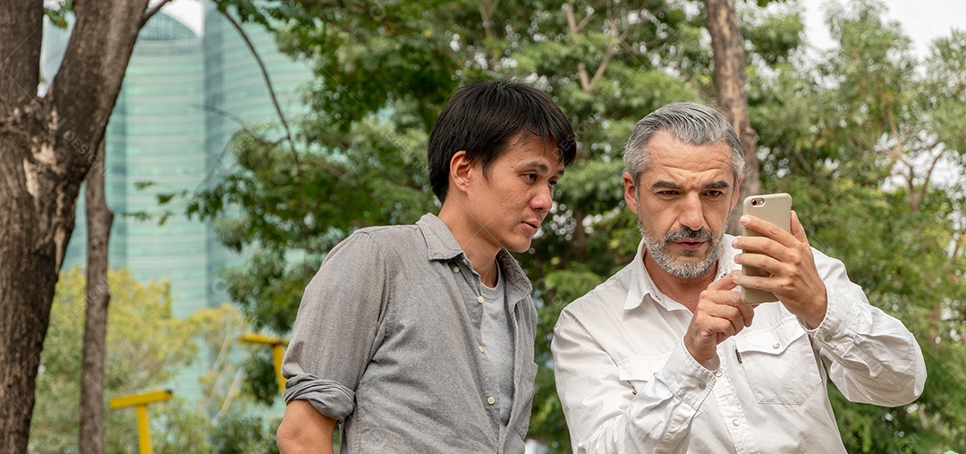 Homem sênior caucasiano pedindo ajuda com a direção do mapa no parque.