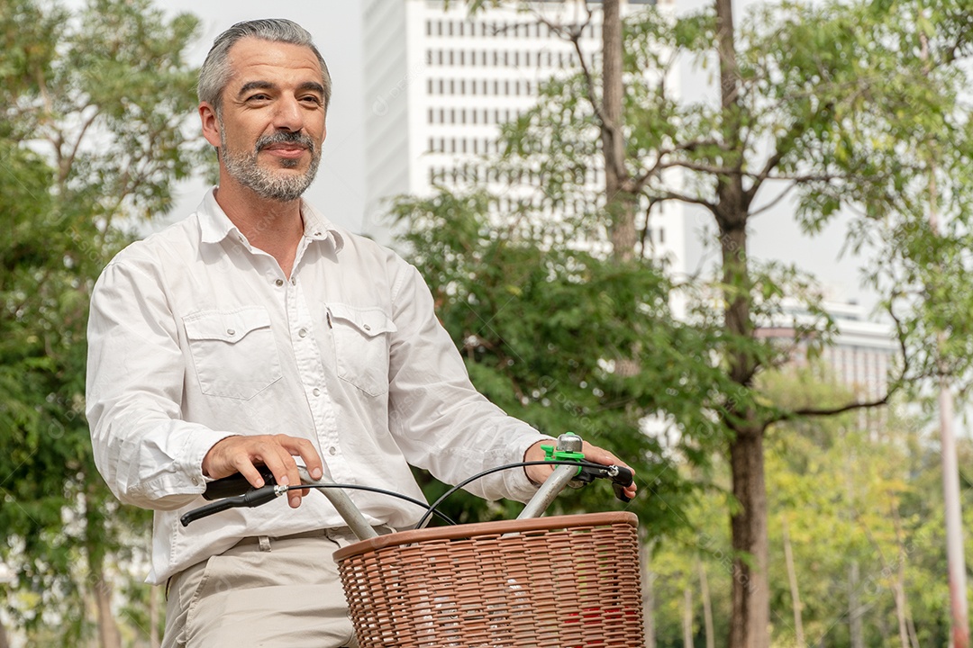 Homem sênior caucasiano andando de bicicleta no parque