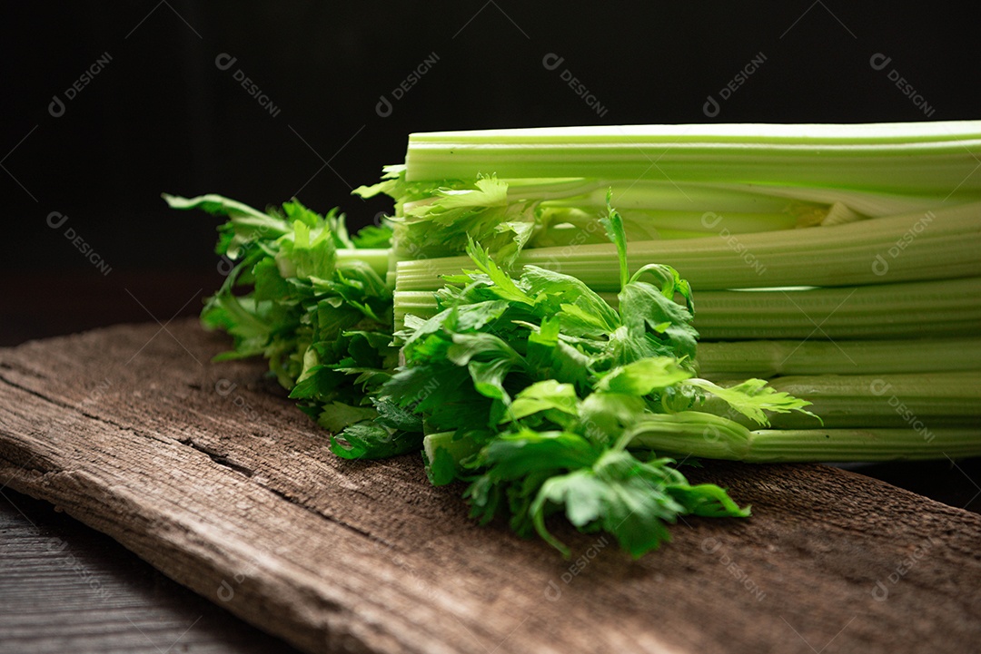 Bando de talo de aipo fresco na mesa de madeira com folhas em fundo preto. Alimentos e ingredientes de vegetais saudáveis. Frescura à base de plantas e baixas calorias para uma dieta com muita vitamina.