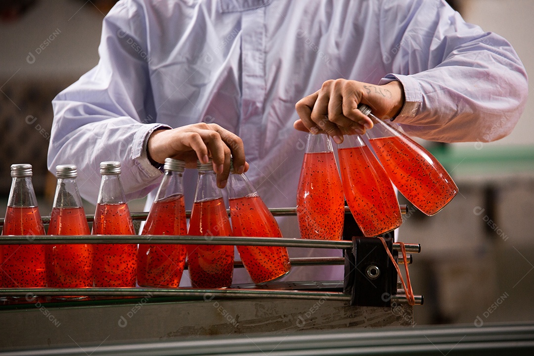 Operário organizando garrafa de suco na produção de engarrafamento