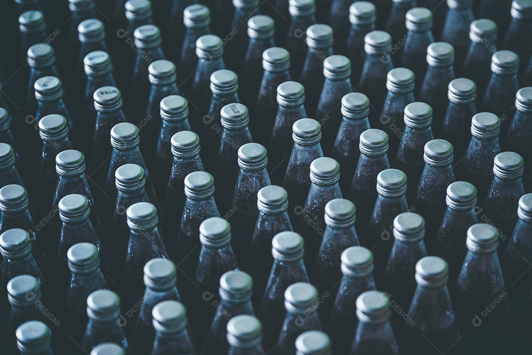 Fila da linha de engarrafamento para processamento no fundo da fábrica de bebidas