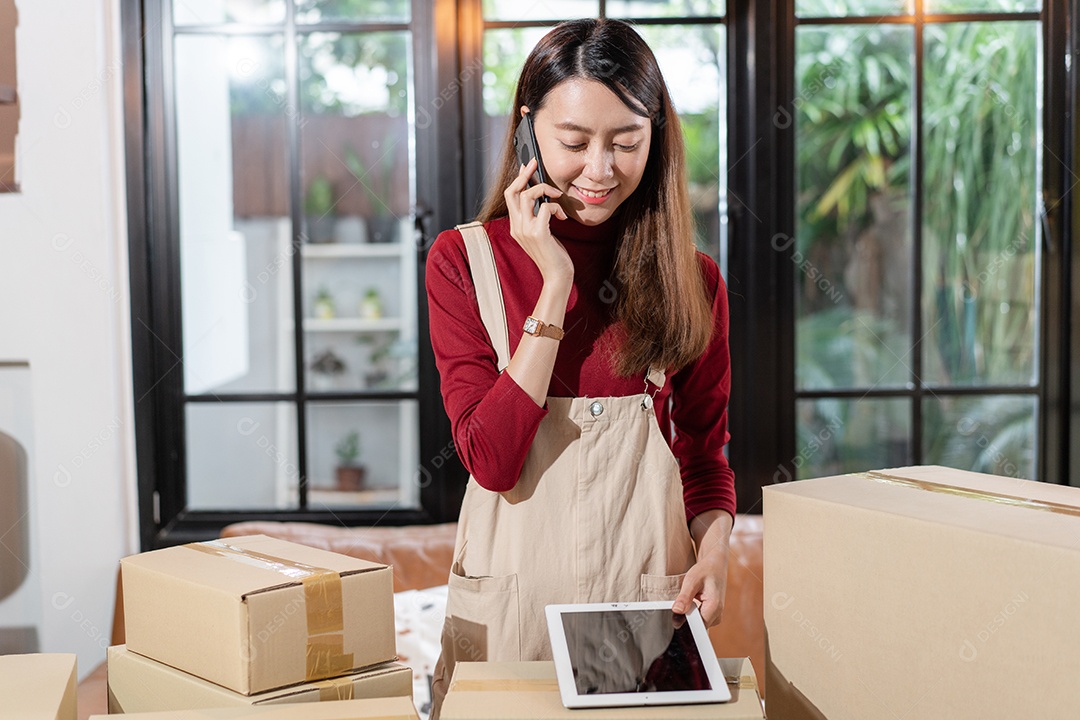 Proprietária de loja asiática ligando para o cliente e verificando o pedido