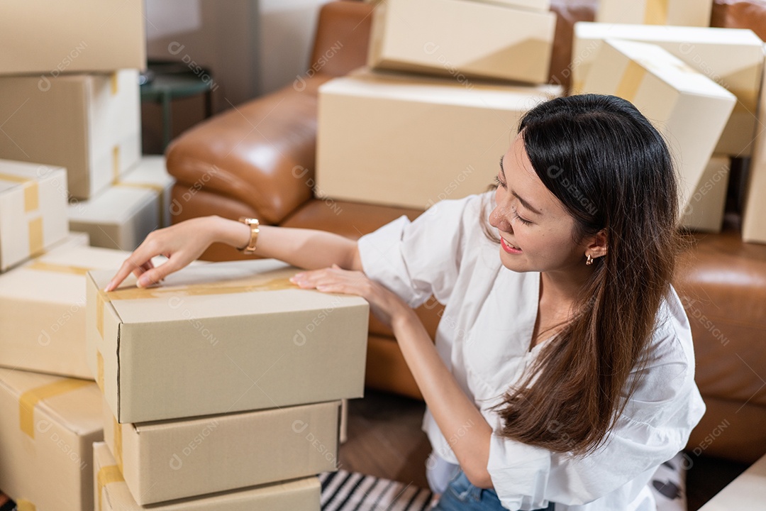 Empresária asiática com caixas de pedidos de clientes