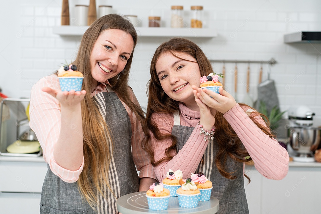 Mãe e filha mostrando cupcakes caseiros