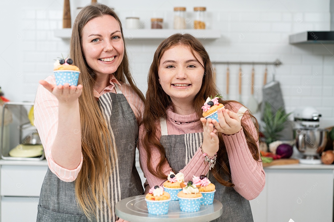 Mãe e filha mostrando cupcakes caseiros