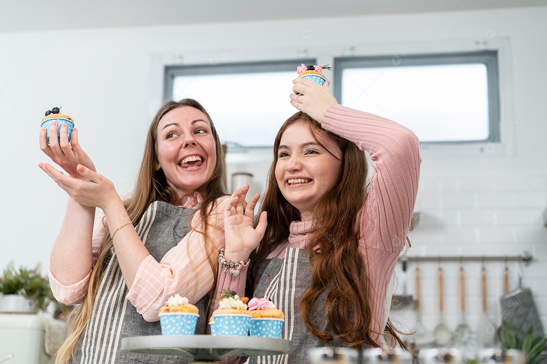 Mãe feliz e filha orgulhosa mostrando bolo caseiro