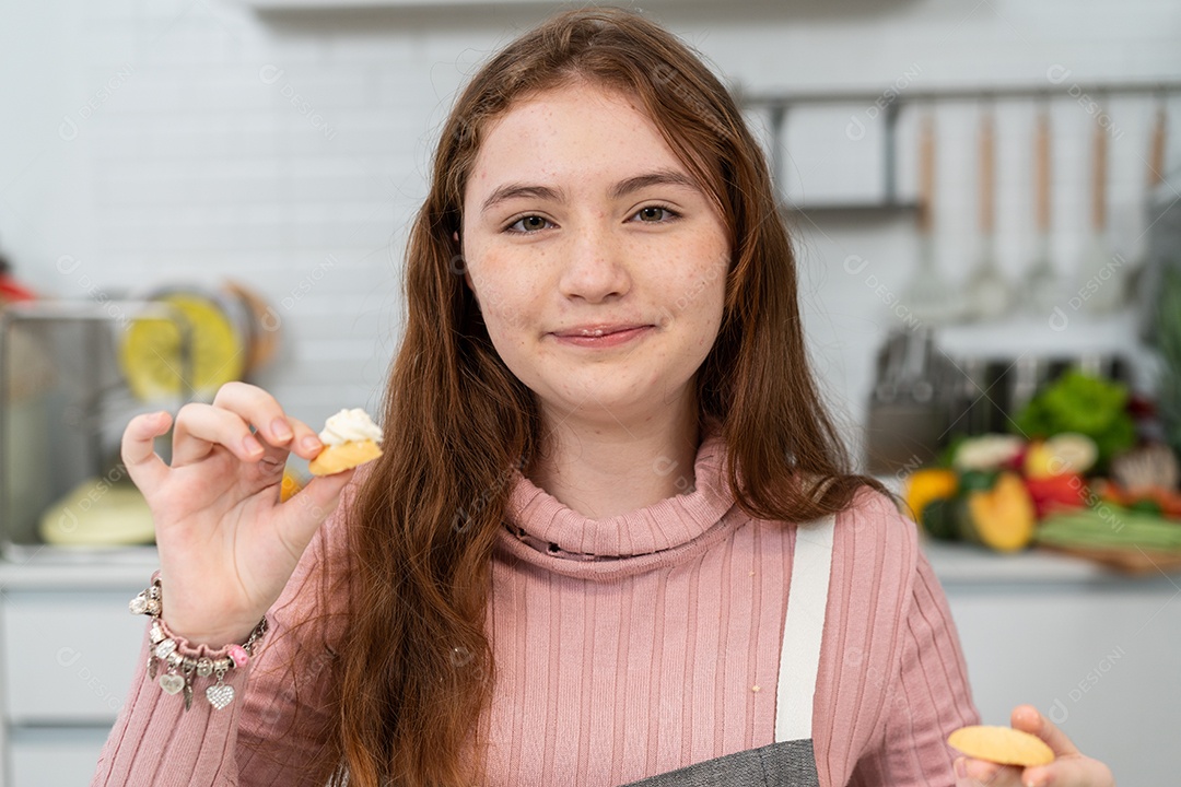 Garota de avental orgulhosa mostrando biscoitos caseiros para a câmera