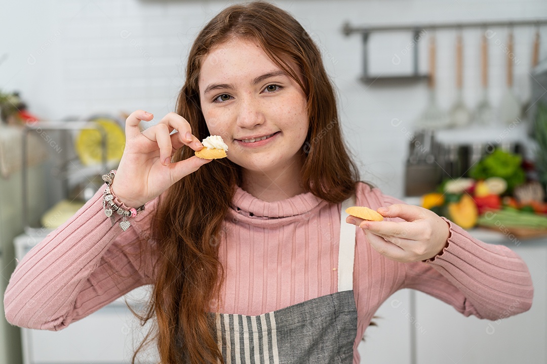 Garota de avental orgulhosa mostrando biscoitos caseiros para a câmera