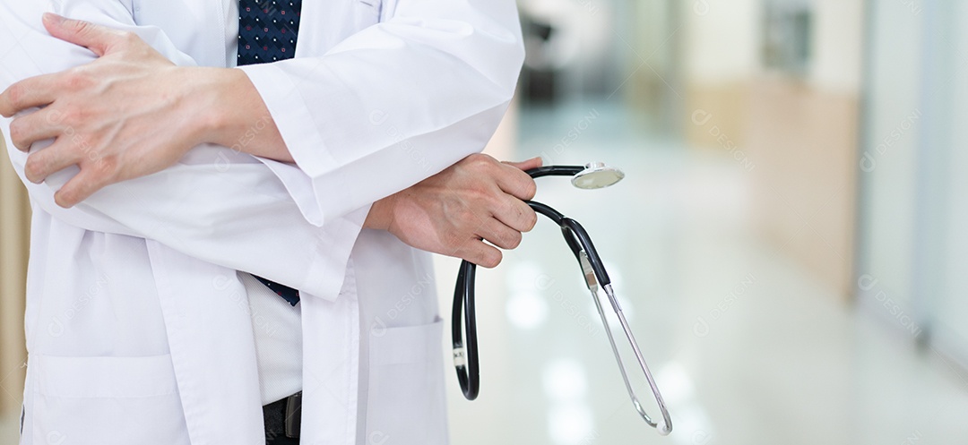 Médico de braços cruzados com estetoscópio em pé no hospital