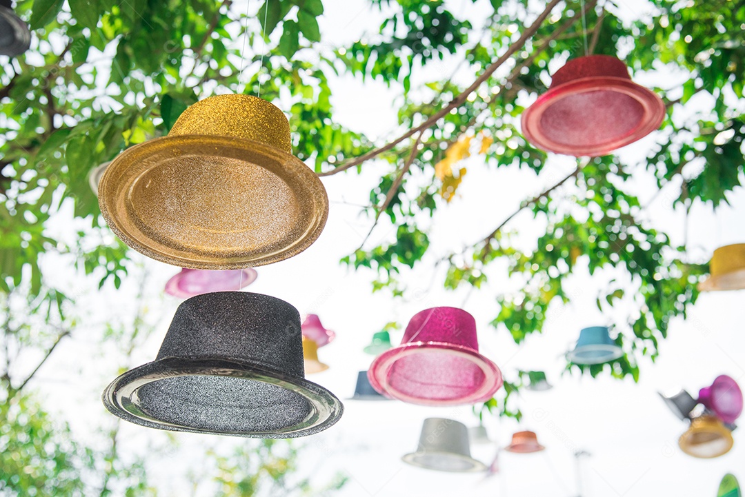 Chapéu flutuante colorido sob grande árvore no parque ao ar livre. Conceito de objeto e plano de fundo. Natureza e tema feito à mão.