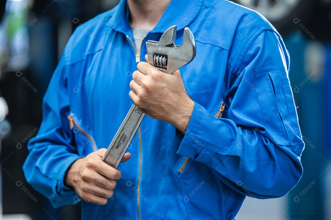 Mão mecânica segurando a ferramenta de equipamento de chave inglesa na garagem de reparo de automóveis