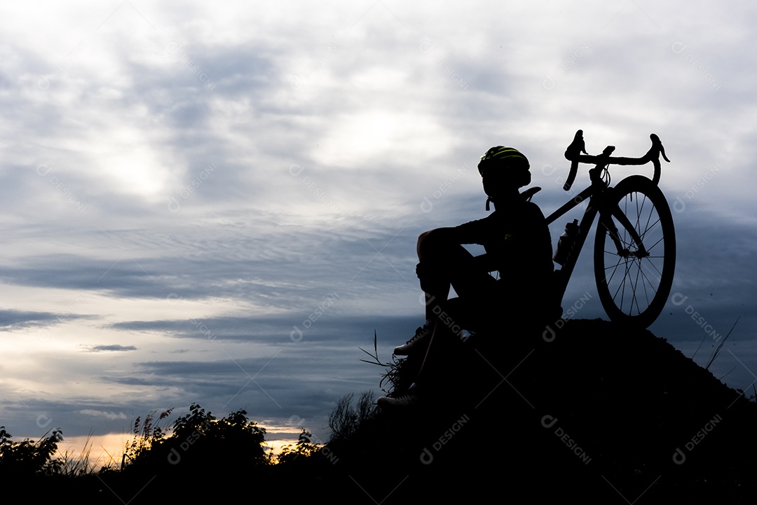 Homem de ciclismo de bicicleta de silhueta na colina. Relaxe e conceito do esporte.