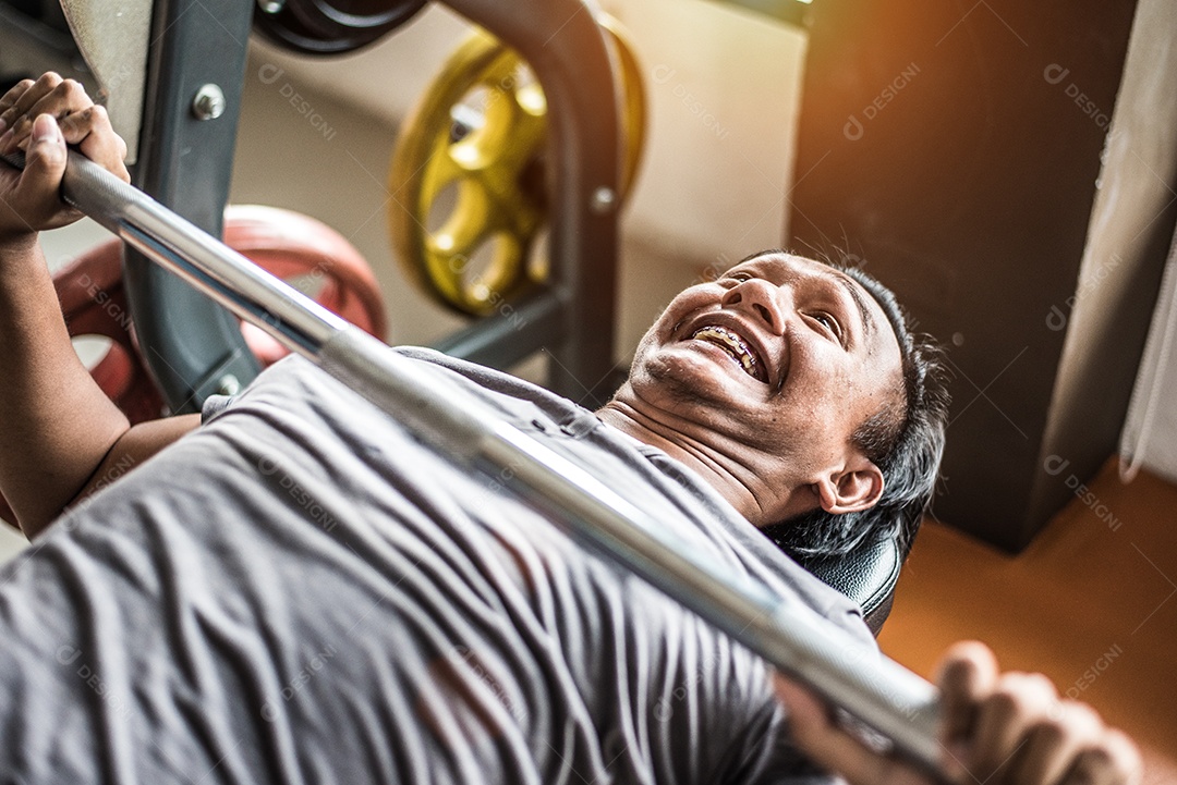 Jovem asiático fazendo levantamento de peso com barra no clube esportivo de ginástica. Conceito de construção de esporte e corpo. Conceito de força e treinamento muscular. Tema engraçado e esforço.