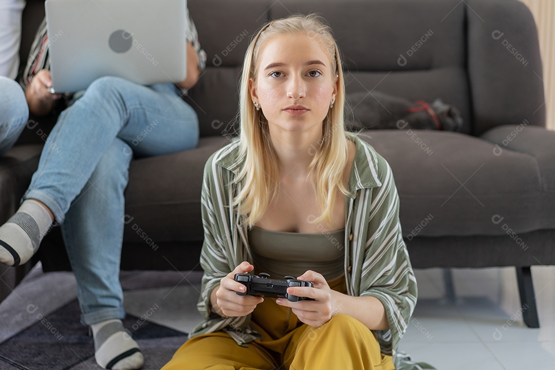 Menina sentada no chão controlando o joystick jogando videogame
