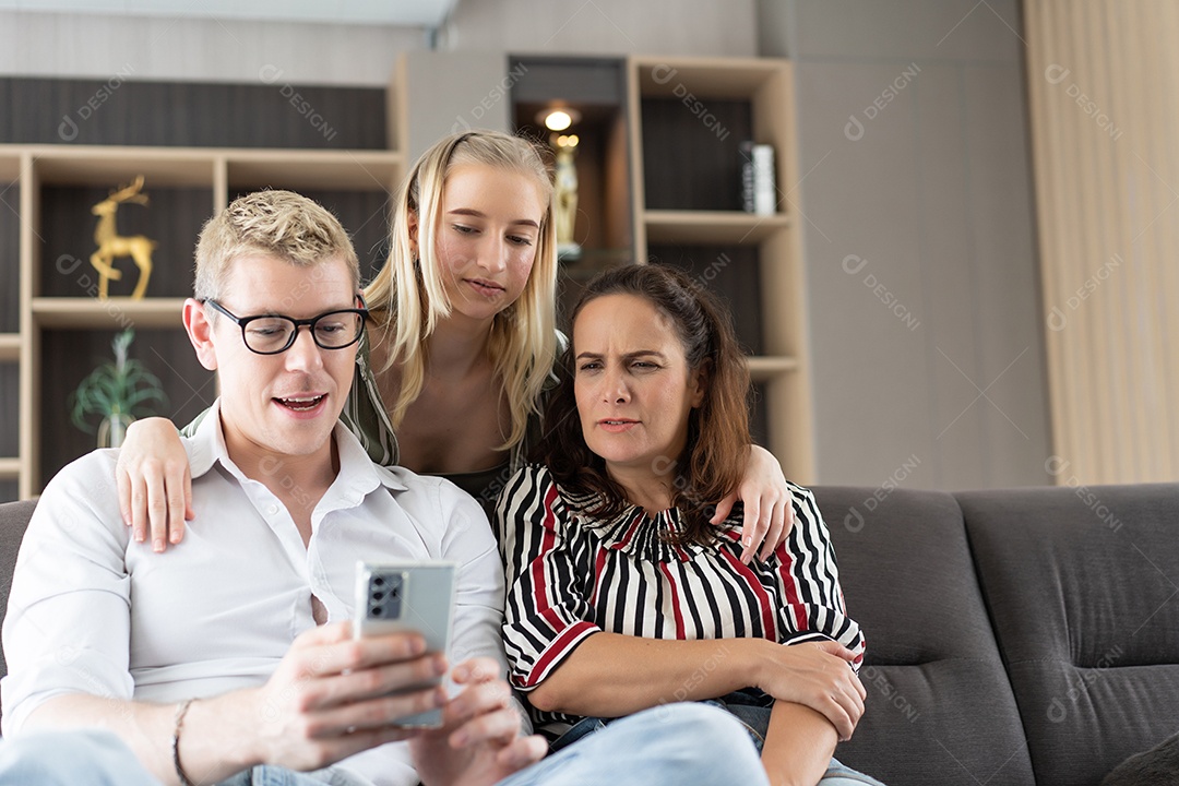 Família caucasiana assistindo ao telefone juntos na sala de estar