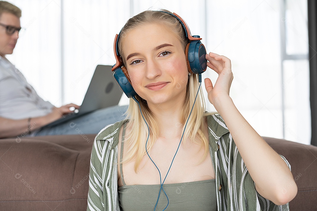 Menina caucasiana feliz ouve música com fone de ouvido relaxando