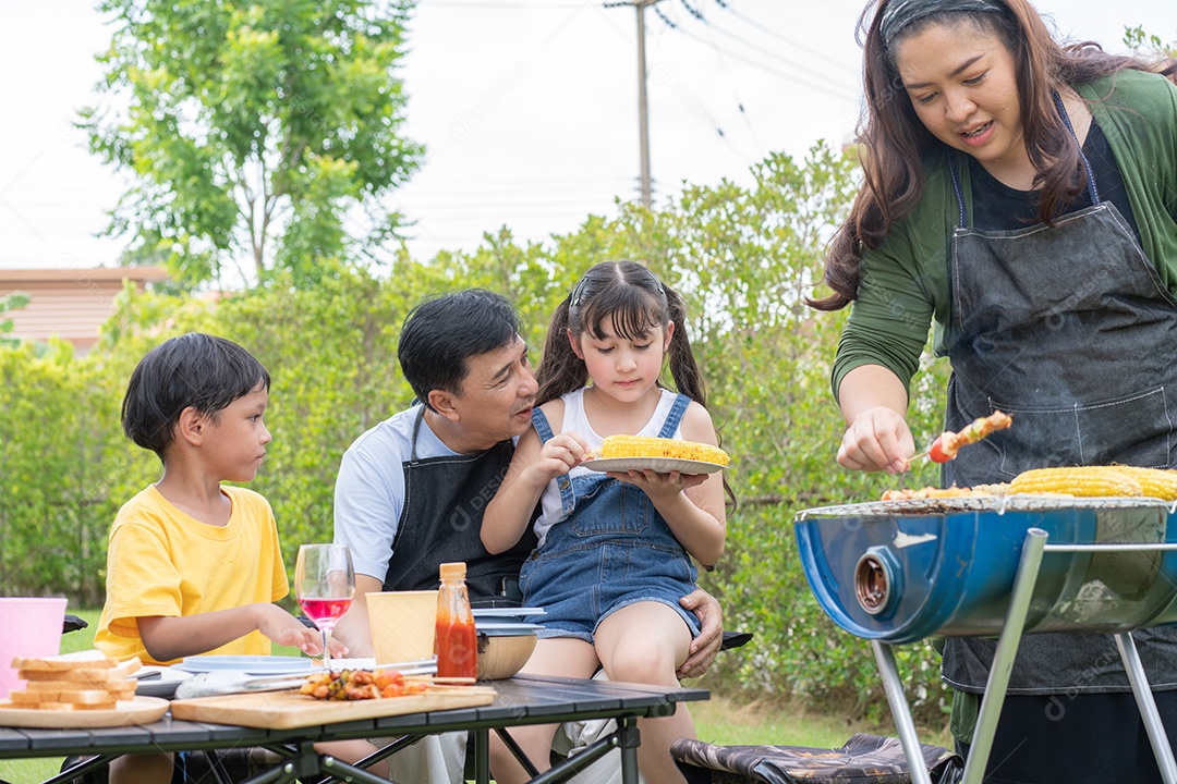 Família asiática fazendo churrasco no quintal