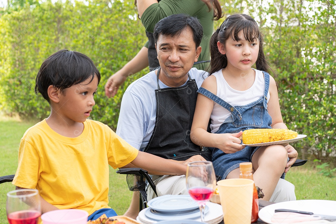 Família asiática fazendo churrasco no quintal
