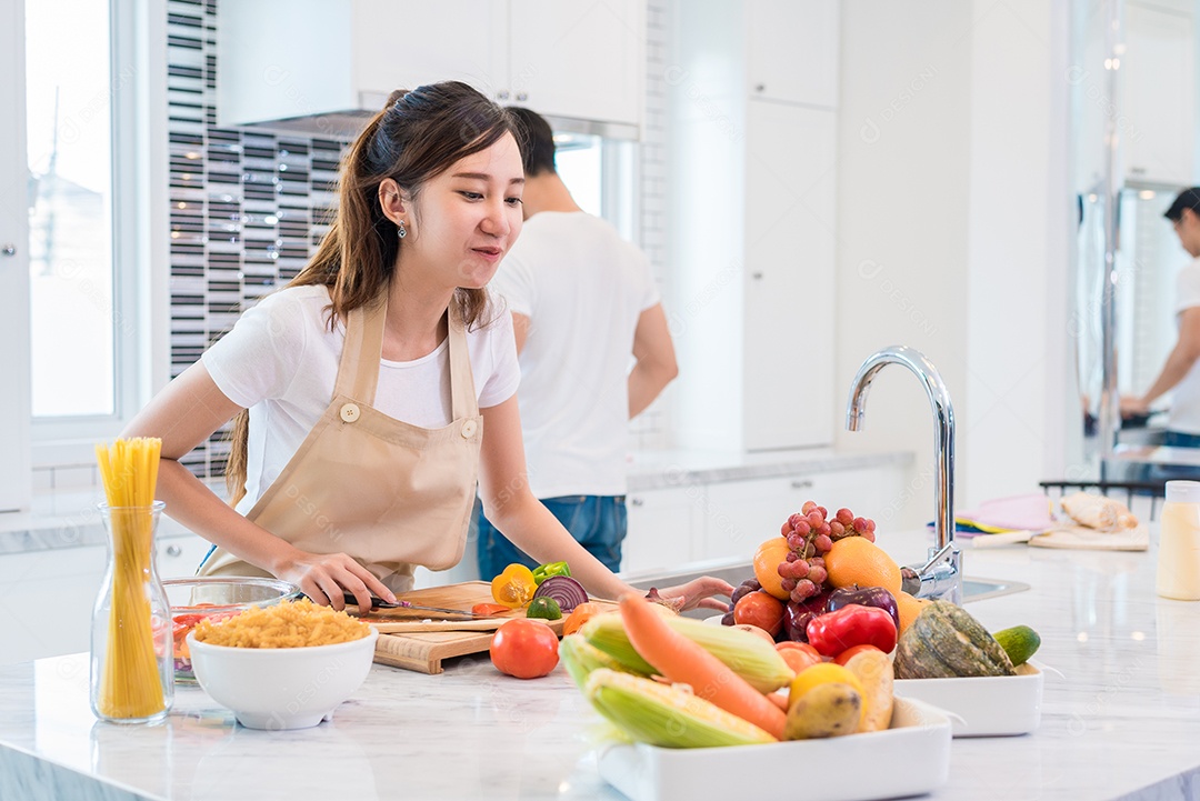 Amantes asiáticos ou casais se preparando e procurando os ingredientes necessários na cozinha com muitos ingredientes na mesa. Conceito de lua de mel e felicidade. Dia dos namorados e conceito de doce lar.