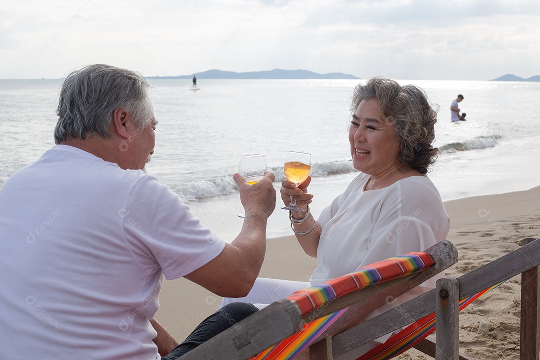 Casal sênior asiático brindando com copos e gosta de beber vinho