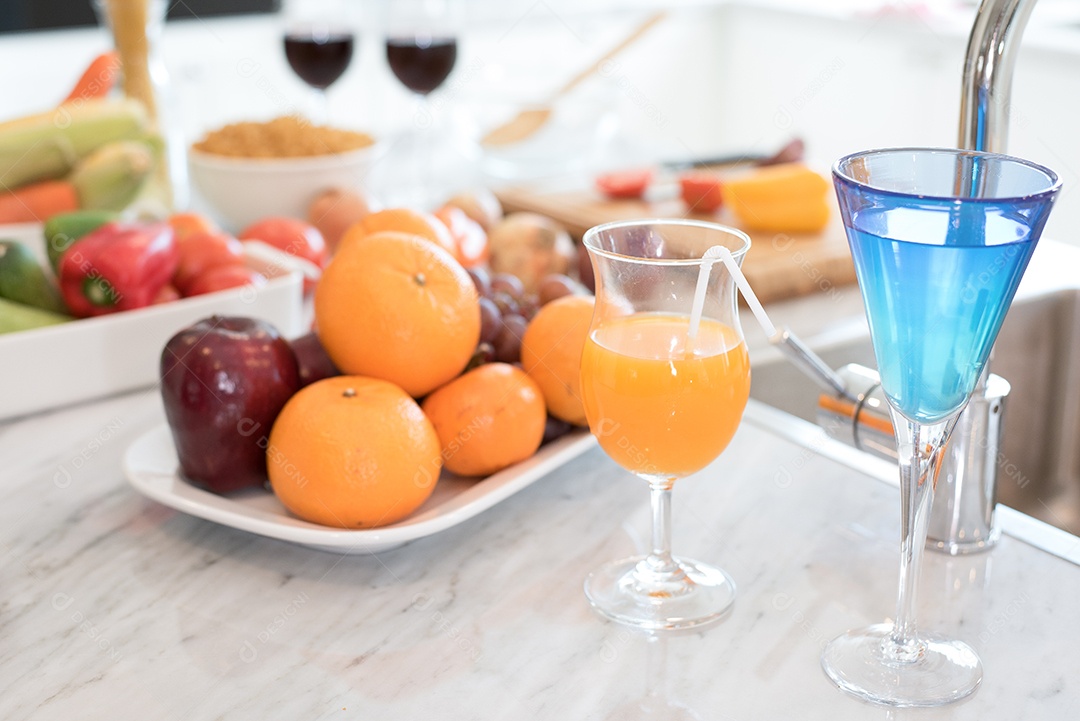 Frutas e suco de frutas no balcão de mármore na cozinha. Maçã e suco de laranja e vegetais na mesa. Conceito de alimentos e bebidas. Tema de festa e celebração