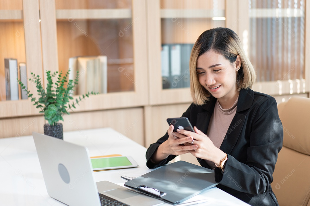 Jovem empresária asiática empresária assistindo telefone celular