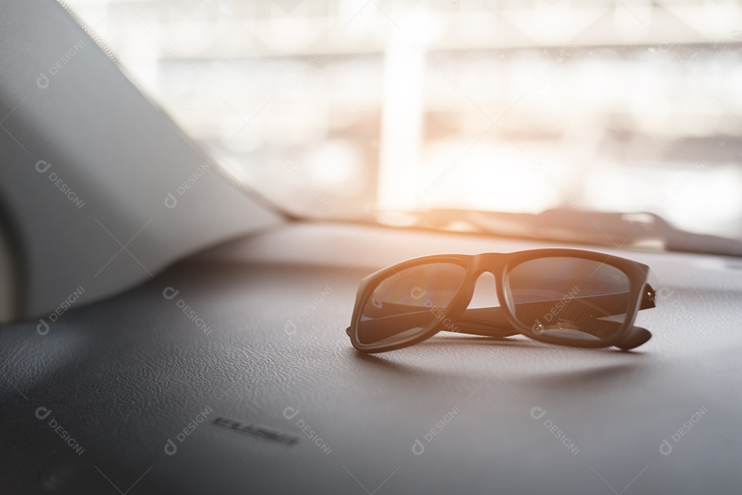 Óculos de sol pretos no console frontal do carro durante a viagem. Tom de processamento cruzado suave e dividido para processos semelhantes a Pinterest e Instagram vintage retrô.