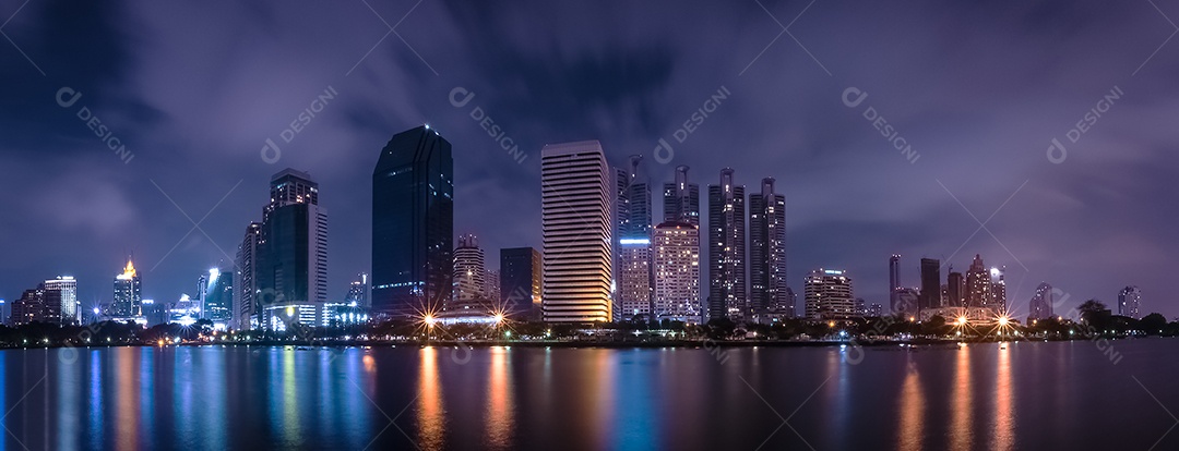 Cidade grande na vida noturna com reflexo da onda de água. Técnicas de longa exposição. Panorama da paisagem. Cidade e conceito urbano. Tema de paisagem e atração.